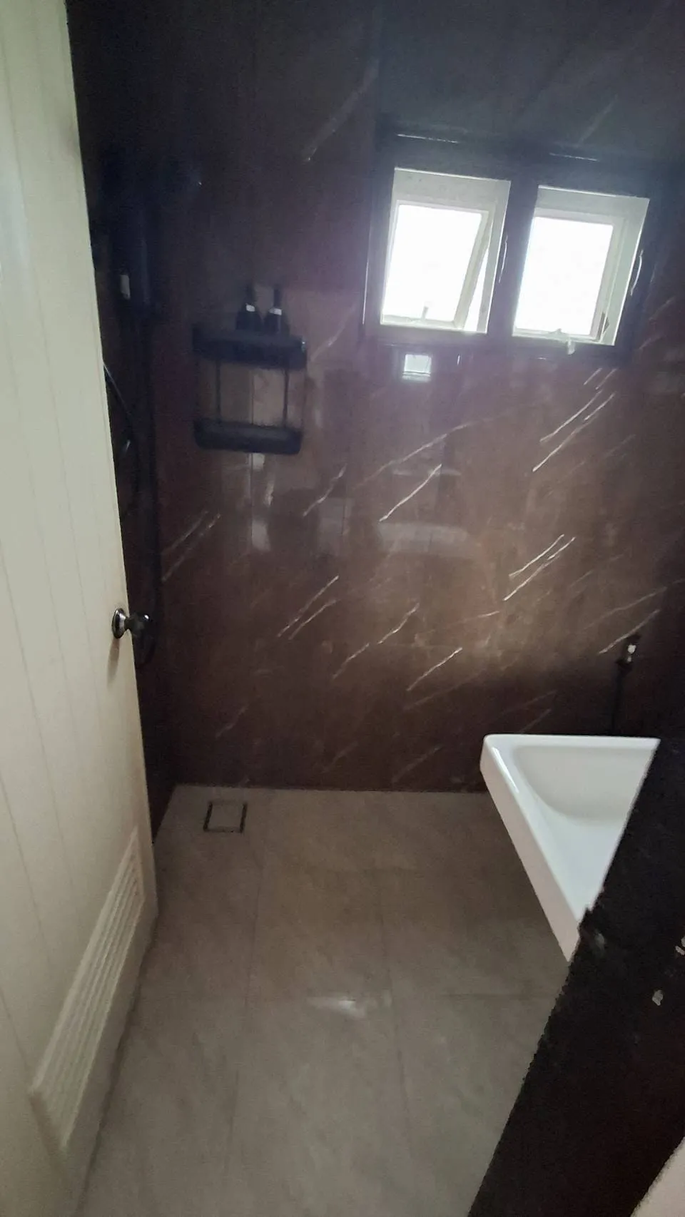 Ensuite bathroom with a bathtub and dark marble-tiled walls