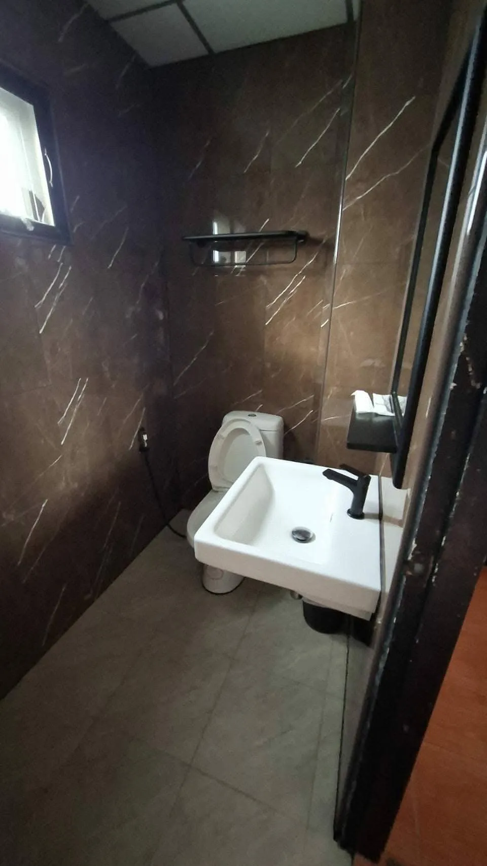 Ensuite bathroom with a walk-in shower, sink and dark marble tiling