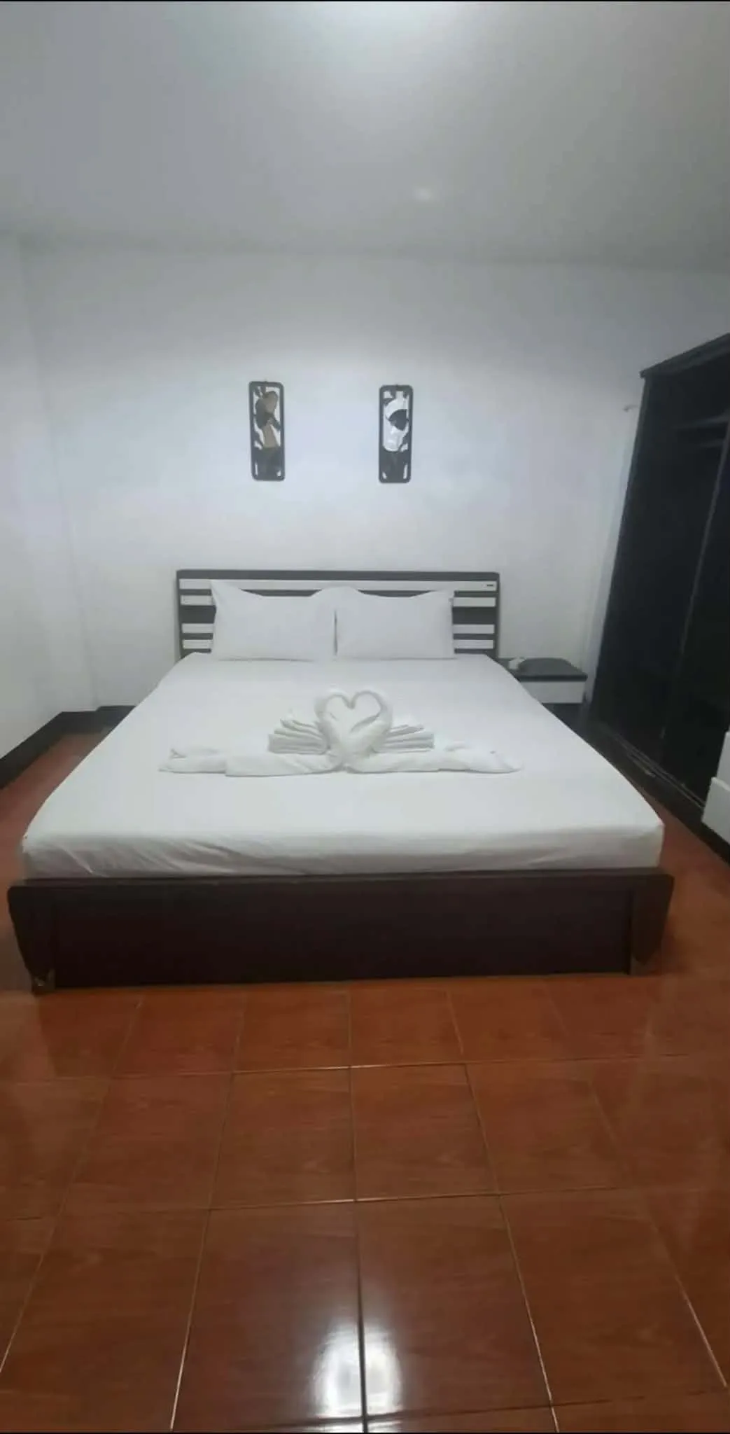 Large Double Room. Double bed with white linen and two framed prints on the wall above