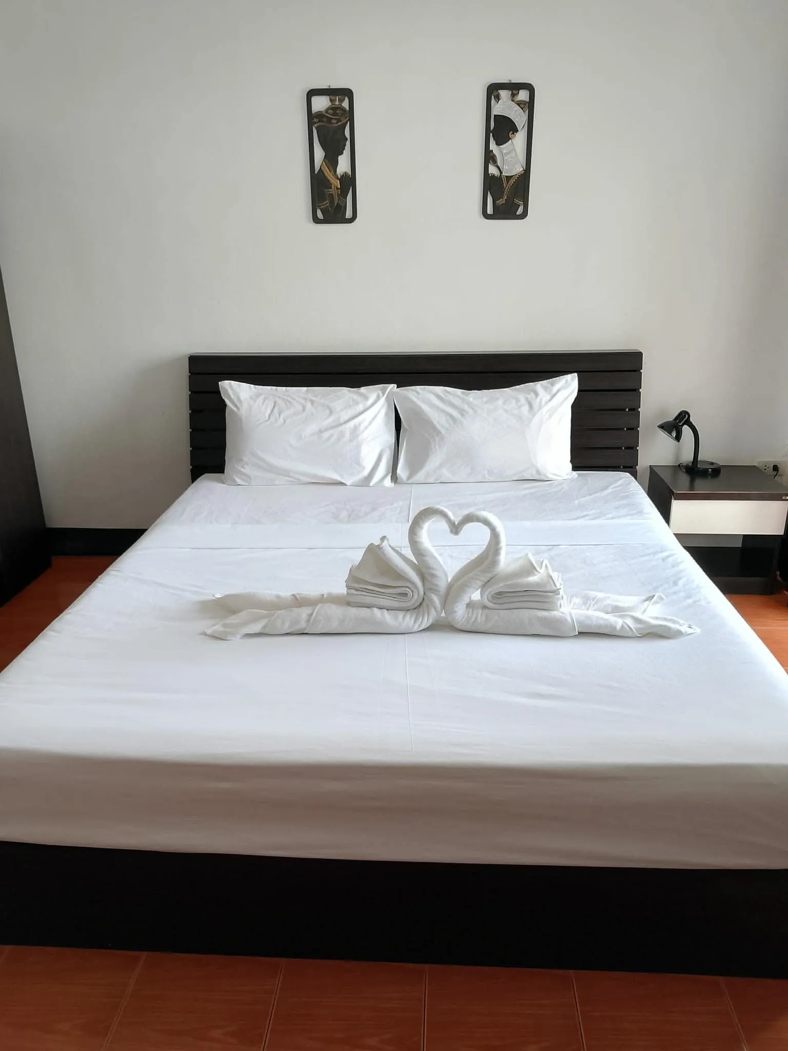A room at Secrets Pattaya with the balcony door open to a city view