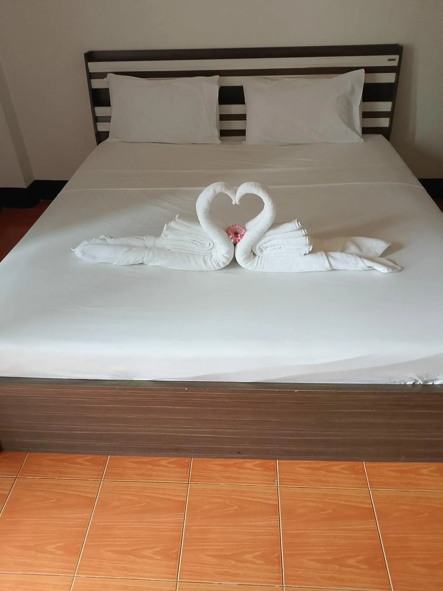 A made bed with slippers set out in a room at Secrets Pattaya