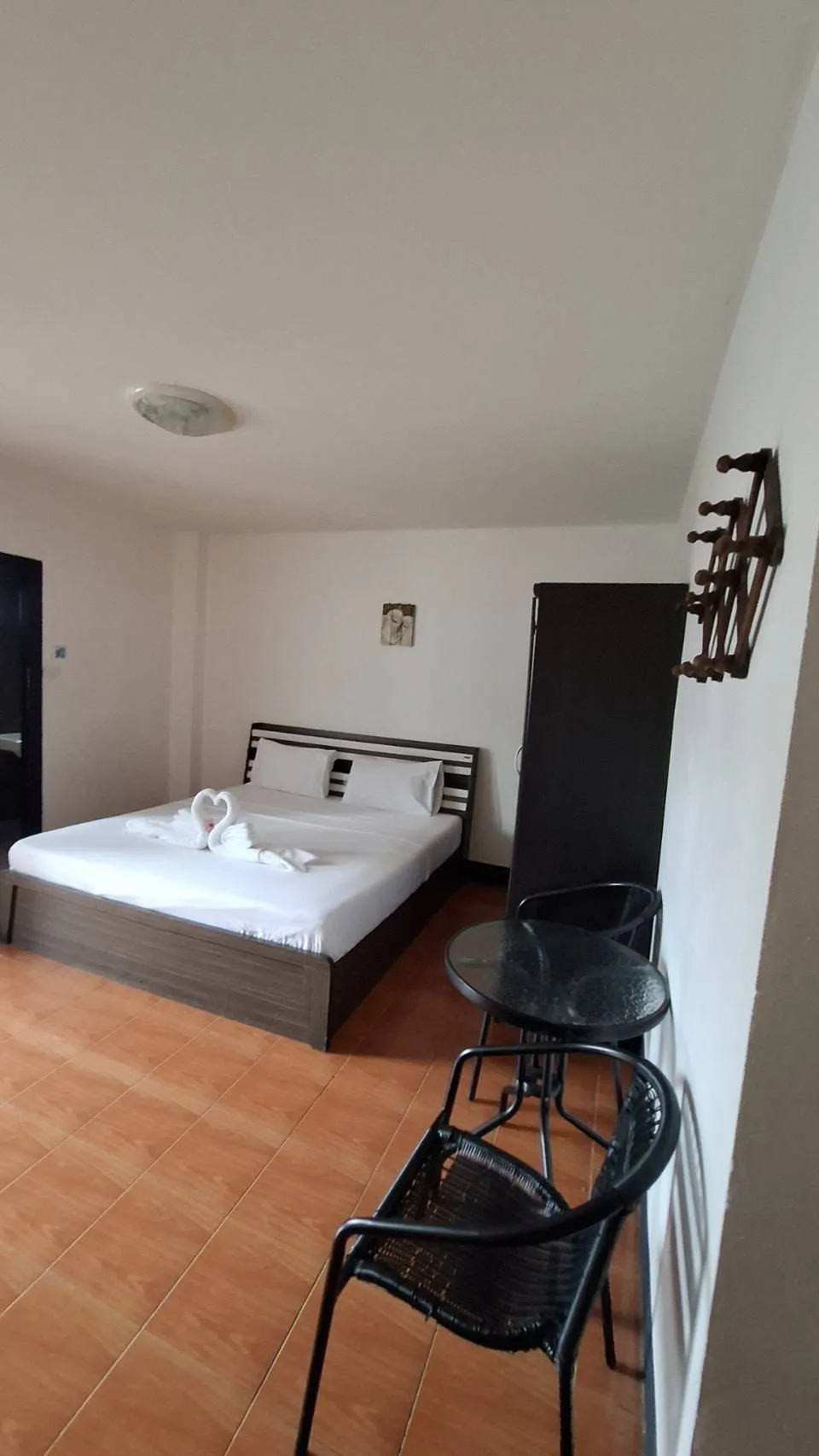 Double bed with a chair and clothes rail beside it